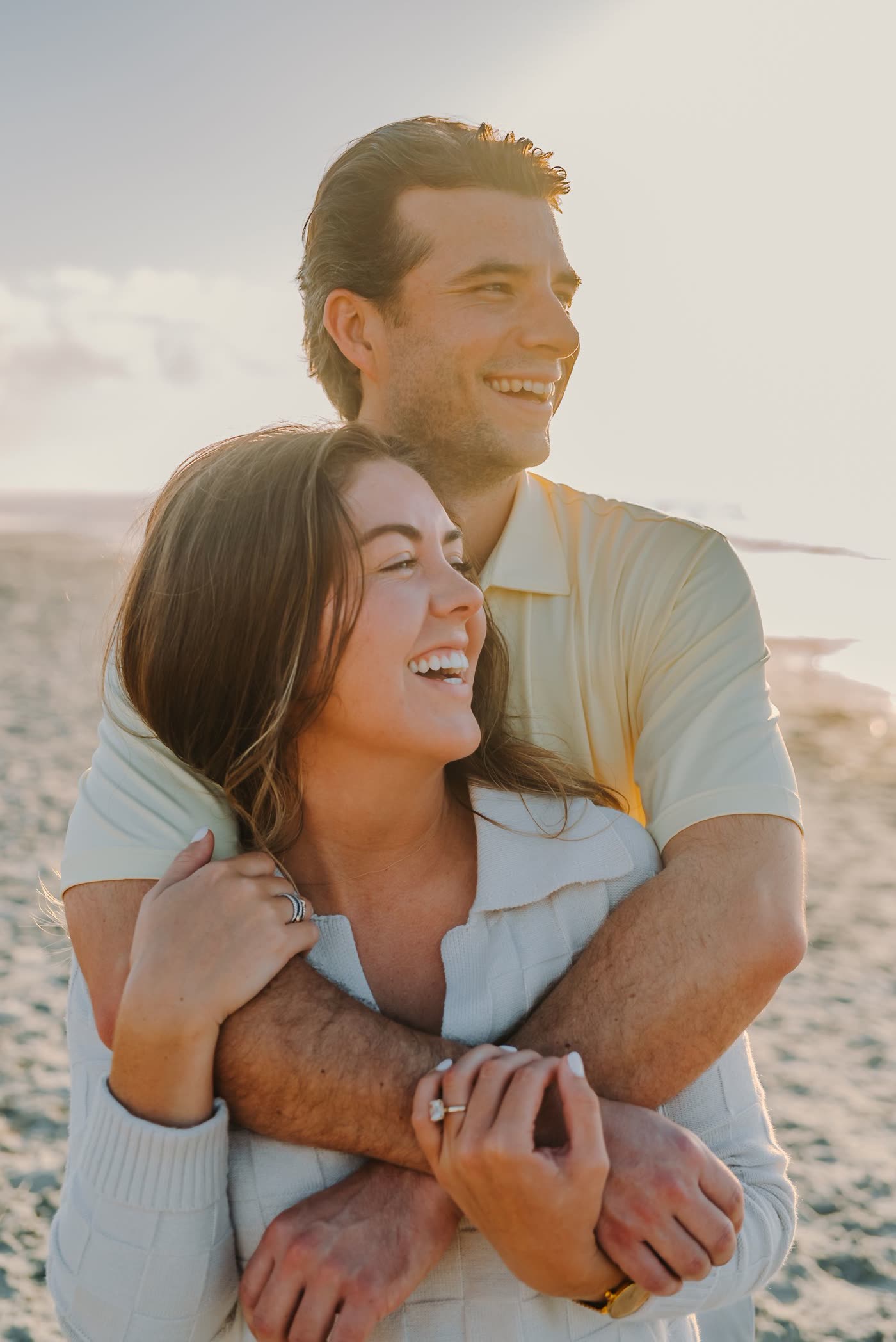 Couple laughing in an embrace on the beach